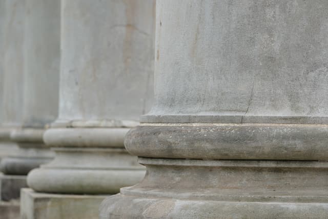 Close-up of weathered stone columns and ledges on a classical building facade