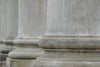 Close-up of weathered stone columns and ledges on a classical building facade