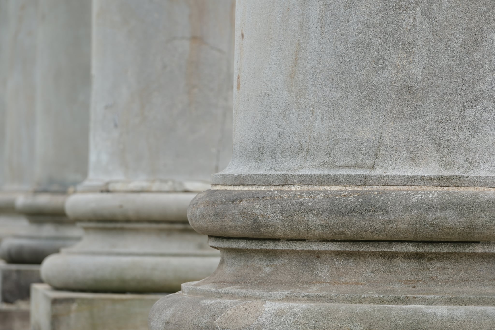 Close-up of weathered stone columns and ledges on a classical building facade